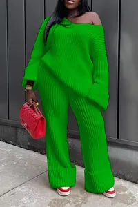 Detail of vibrant green two-piece knit set featuring off-shoulder sweater and wide-leg pants.