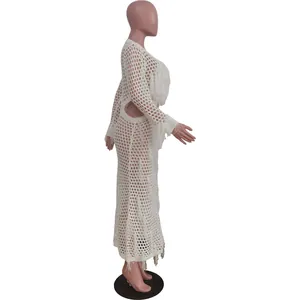 Detailed side view of white crochet hollow-out beach dress with fringe on a mannequin