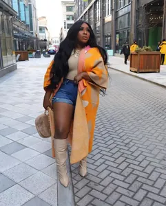 Streetstyle-Mode mit einem orangefarbenen und beige gemusterten langen Strickcardigan