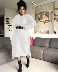 Elegant white cable-knit long sweater dress featuring side fringe and a black belt