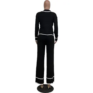 Vue arrière d'un ensemble en maille noir pour femme avec rayures blanches et pantalon large.