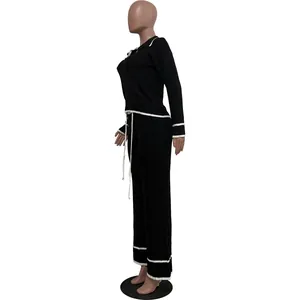 Vue latérale détaillée d'un ensemble deux pièces en tricot noir avec passepoils blancs élégants