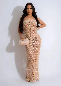 Detailed macro view of a beige crochet strapless maxi dress with colorful sequins for beach