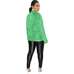 Vue arrière d'une femme en blazer à paillettes vert brillant et legging en cuir noir