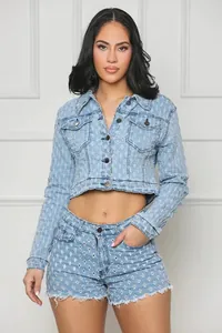 Vista completa de un conjunto de chaqueta y pantalones cortos de mezclilla azul con rotos.