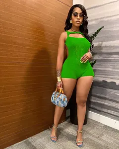Close-up of vibrant green sleeveless knit romper with openwork crochet texture