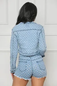 Vista trasera de un conjunto de chaqueta y pantalones cortos de mezclilla desgastados.