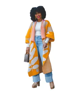 Detaillierte Ansicht eines langen Damen-Strickcardigans mit auffälligem orange-weißem Blattmuster