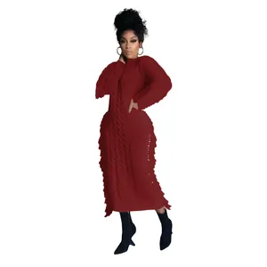 Red long-sleeved cable knit sweater dress featuring decorative fringe side details
