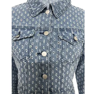 Primer plano detallado de chaqueta vaquera azul claro con rotos y botones metálicos.