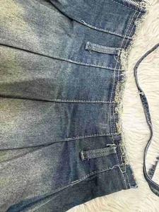 Primer plano que muestra la textura de lavado vintage y los bordes deshilachados de la falda