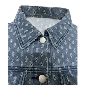 Detalle del cuello de una chaqueta vaquera azul rota con botón plata