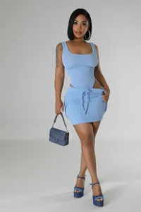 Full view of light blue ribbed bikini top and matching mini skirt on model posing