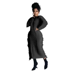 Detailed view of black cable knit long dress featuring unique tassel fringe edges