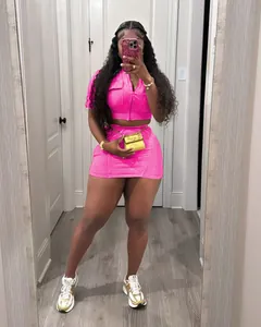 Détail d'un ensemble deux pièces rose vif composé d'un gilet zippé et d'une mini-jupe
