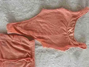 Close-up of coral textured Jacquard two-piece set featuring bikini top and skirt
