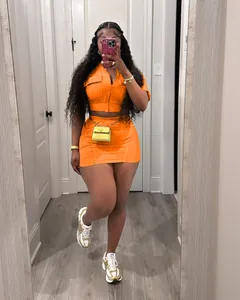 Selfie miroir d'un ensemble deux pièces orange avec gilet zippé et minijupe