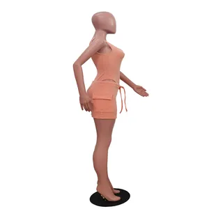 Side profile of orange ribbed two-piece set featuring crop top and cargo mini skirt