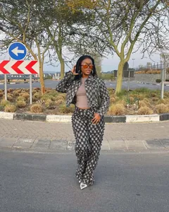 Full view of a woman wearing a distressed checkerboard jacquard denim jacket and pants set.