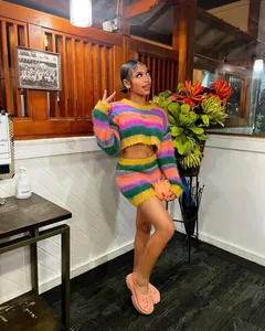 Ganzkörperansicht eines Models in einem bunt gestreiften Strick-Crop-Top und Minirock-Set