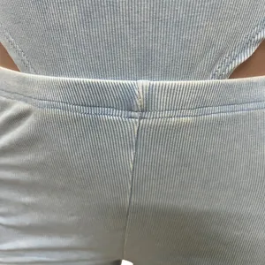 Close-up of light blue ribbed knit fabric showing stitching detail at the waist