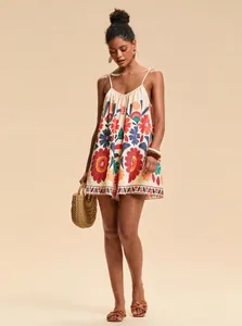 Full length view of a stylish bohemian floral romper on a fashion model carrying a straw bag