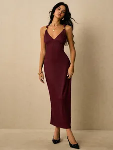 Elegant burgundy plissé maxi dress with gold ring shoulder detail and deep V-neckline
