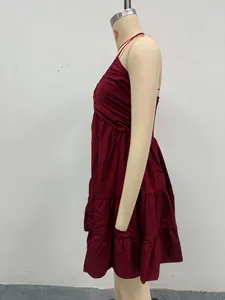 Side view of a burgundy tiered ruffled summer dress with spaghetti straps on a mannequin