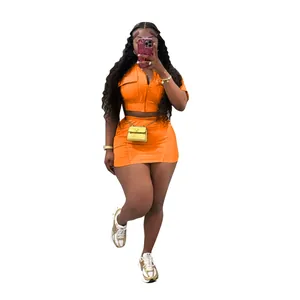 Gros plan sur un ensemble jupe deux pièces orange vif avec haut zippé et mini-jupe