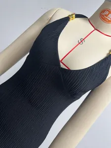 Close-up detail showing the pleated fabric texture and elegant V-neckline of the dress.