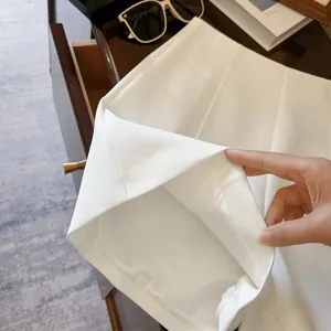Gros plan sur l'ourlet et la doublure de ce short de costume blanc minimaliste taille haute.