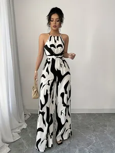 Chic black and white cow print halter neck wide-leg jumpsuit with waist tie detail