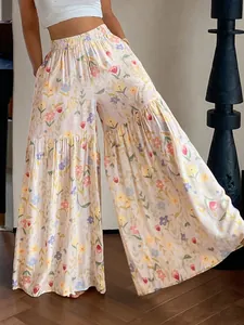 Détail du pantalon large à fleurs à taille haute montrant le tissu fluide et coloré.