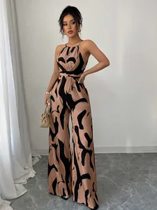 Elegant halter neck wide-leg jumpsuit featuring bold black and tan abstract patterns