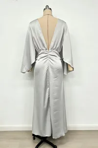 Back view of elegant silver satin maxi dress featuring deep V-back and ruched fabric details