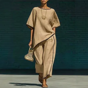 Ensemble beige élégant avec liseré noir, haut ample et pantalon large.