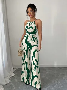 Detail view of a green and white abstract print halter wide-leg jumpsuit on model