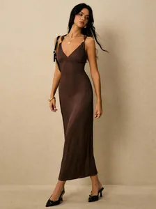 Full-length view of an elegant brown ribbed maxi dress with gold-toned strap accents.