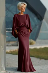 Elegant burgundy pleated maxi dress with pockets in a sophisticated outdoor setting