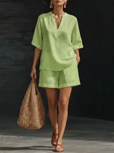 Modèle portant un ensemble décontracté deux pièces en lin vert clair avec sac