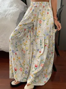 Gros plan d'un pantalon large à fleurs à taille haute en tissu fluide et léger