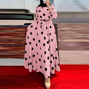 Close-up of a pink long-sleeved maxi dress featuring a bold black polka dot print
