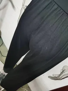 Close-up of black high-waisted wide-leg yoga pants showing fabric texture and loose fit.