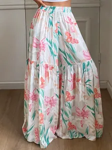 Détail de ce pantalon large à fleurs à taille haute avec un drapé de tissu fluide.