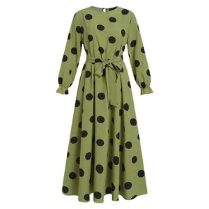 Close-up of green polka dot maxi dress with long sleeves and waist tie detail