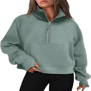 Close-up of sage green half-zip sweatshirt with stand collar and thumb hole cuffs