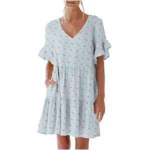 Detail of a V-neck light blue dress featuring a sweet cherry print and ruffled sleeve edges.