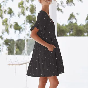 Detail view of black polka dot V-neck dress with ruffle sleeves and side pockets.