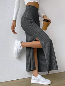 Detail view of a grey high-waisted ribbed knit maxi skirt with a stylish side slit.