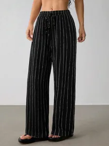 Detailaufnahme der schwarzen Damen-Nadelstreifen-Hose mit weitem Bein und Kordelzug im Bund.